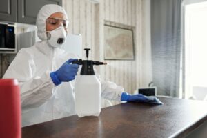 Profissional com EPI fazendo sanitização de ambiente